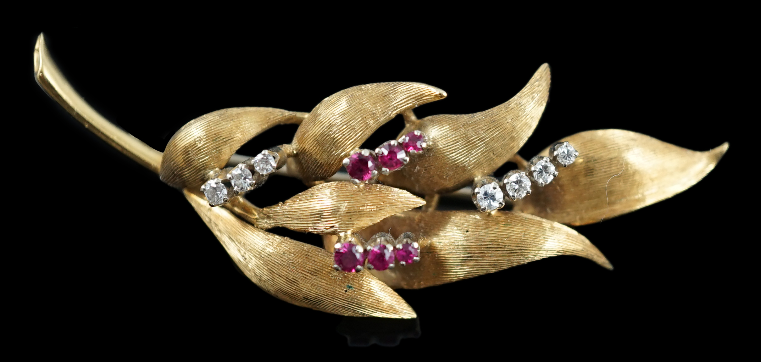 A 1960's 18ct gold, six stone ruby and seven stone diamond chip set leaf spray brooch